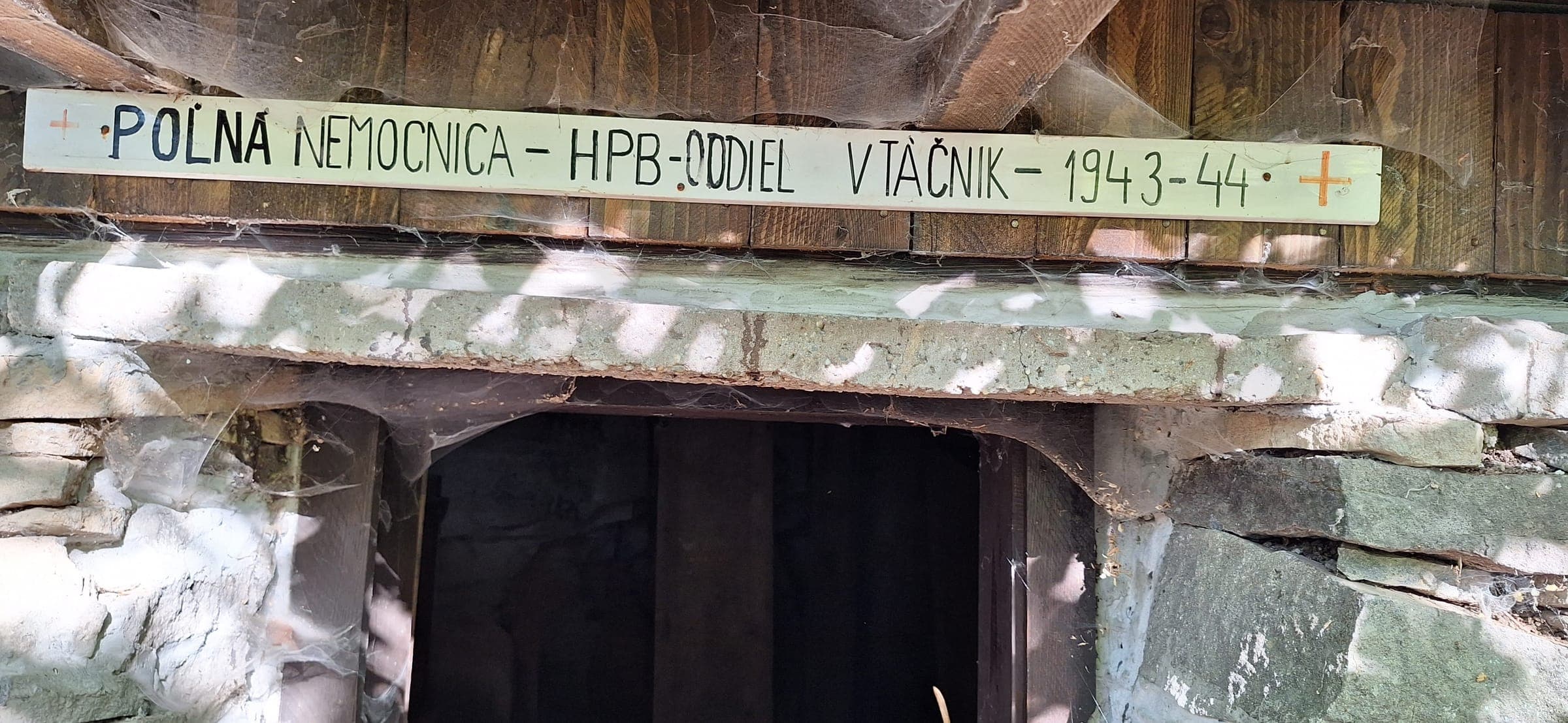 Nápis nad vchodom: Poľná nemocnica – HPB – oddiel Vtáčnik – 1943 – 44.
